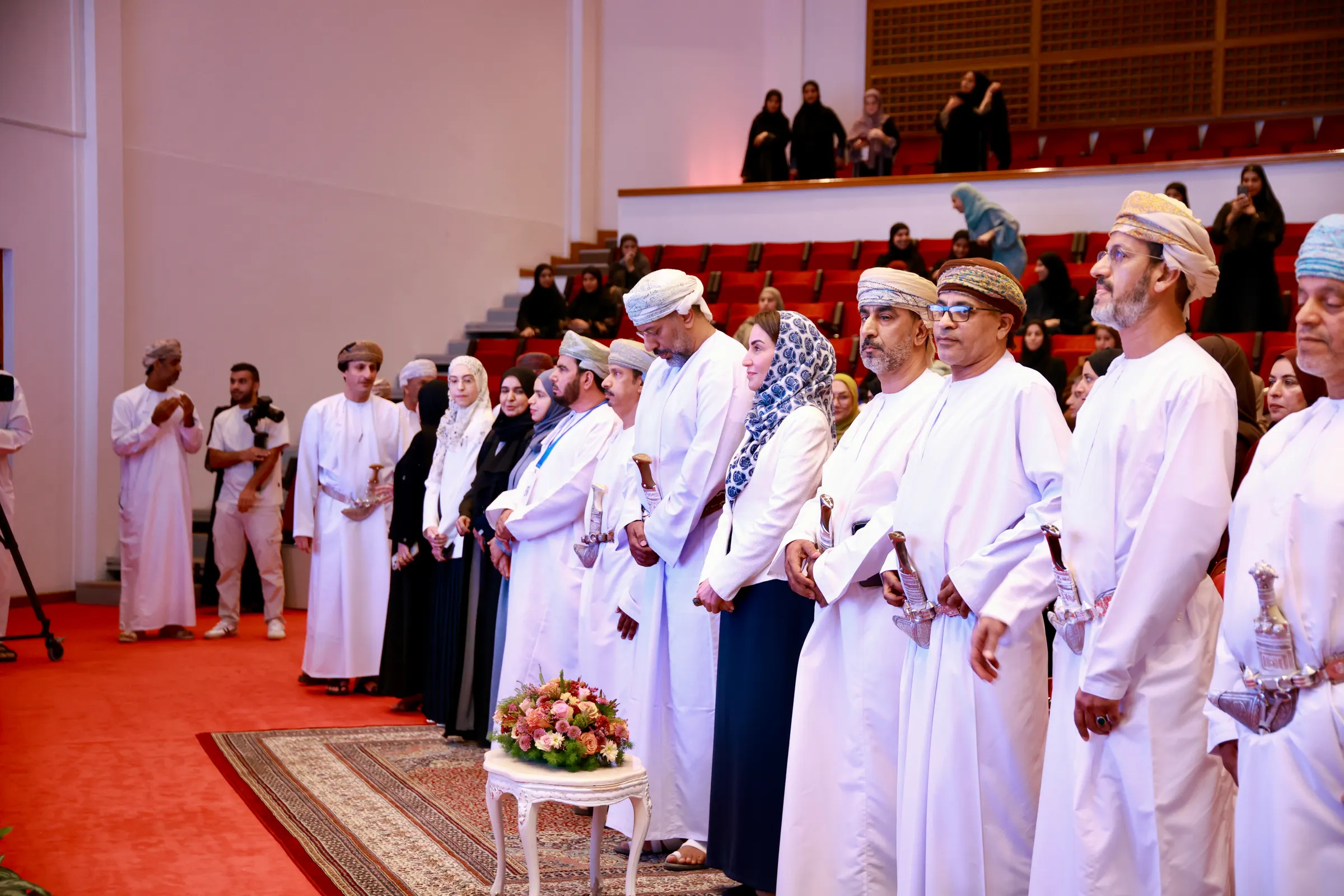 صف من المكرَّمين والمكرَّمات بالزي العُماني خلال حفل ملتقى آفاق